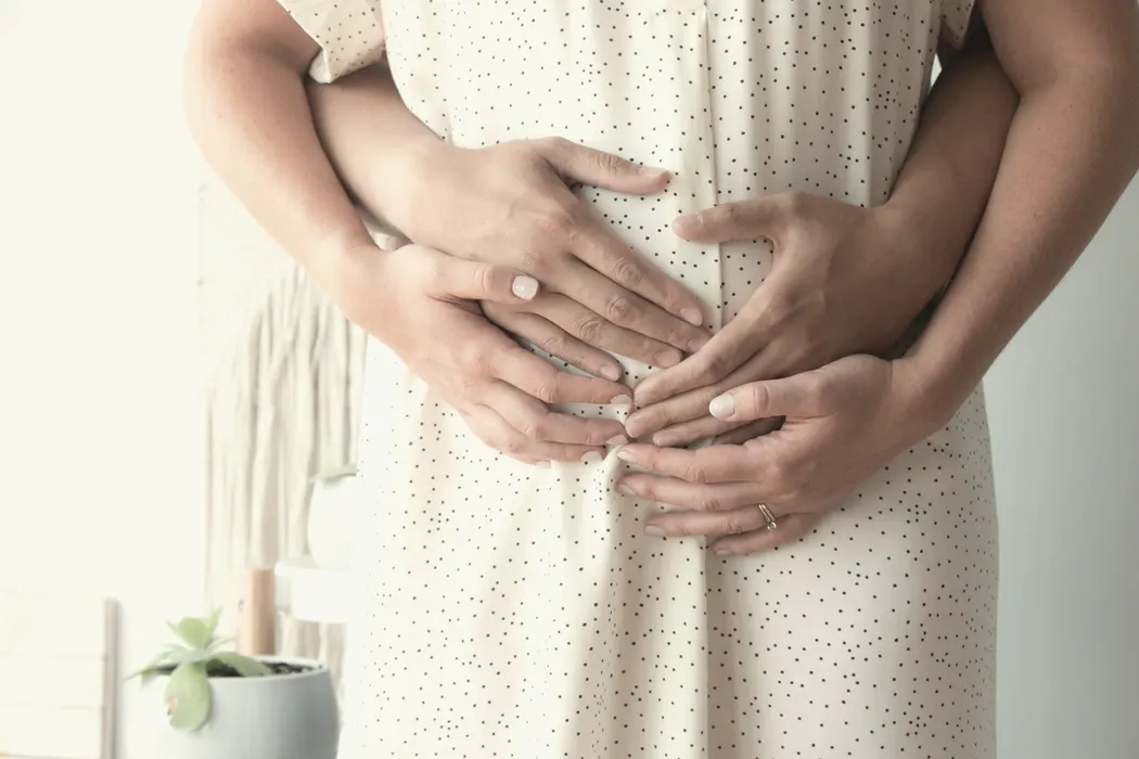 Mani di una coppia sul ventre in gravidanza